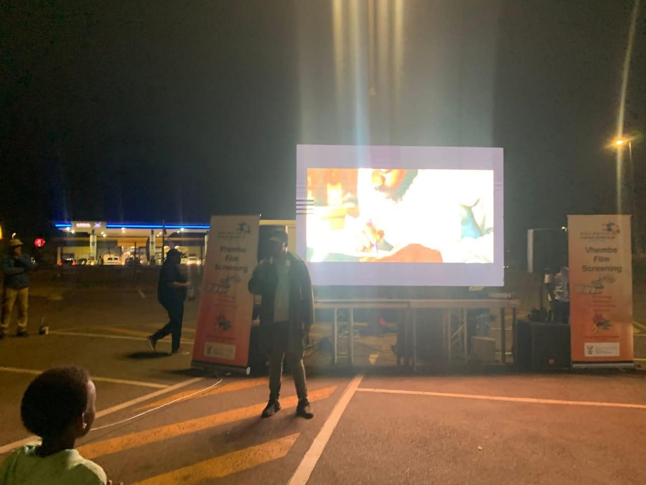 Screen and stage at an outdoor evening event