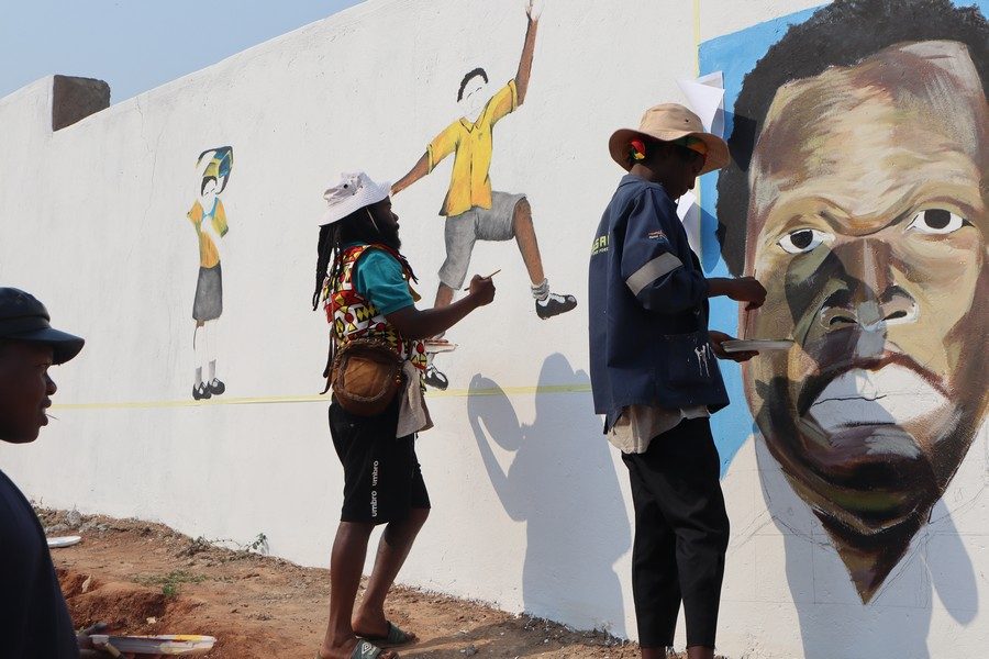 Artists painting a large mural